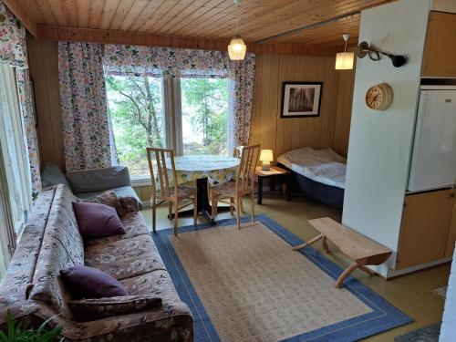 a living room with a couch and a table at Lakeside Hilda, rantamökki 