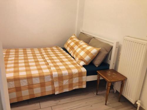 uma pequena cama com duas almofadas e uma mesa em David's House em Tessalônica
