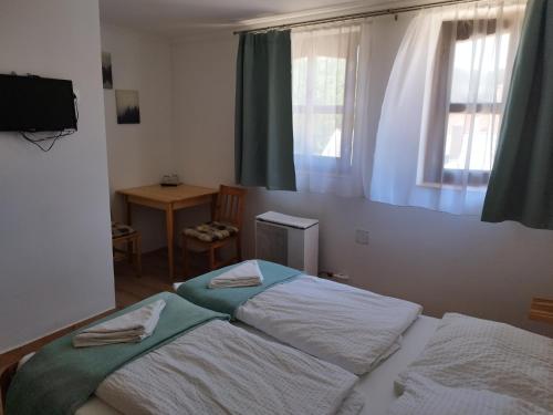 1 dormitorio con 2 camas y ventana en Privát Fogadó és Étterem, en Bükkszentkereszt