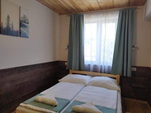 a bed in a room with a window and a bedvisor at Privát Fogadó és Étterem in Bükkszentkereszt