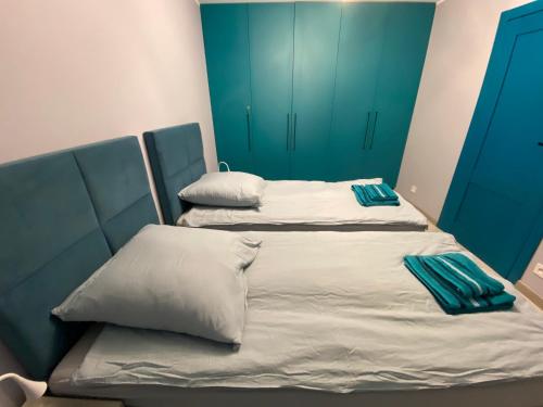 two twin beds in a room with blue cabinets at Apartament Ardea Rowy in Rowy