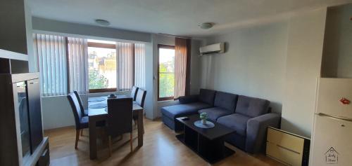 a living room with a blue couch and a table at Lindy Home in Burgas