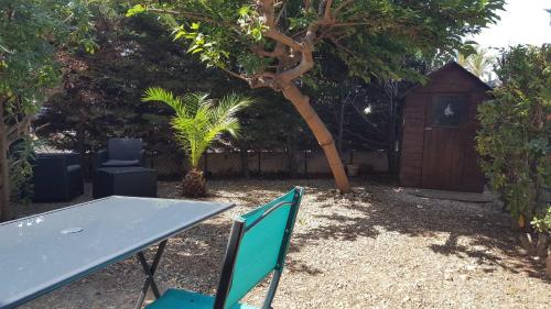 una mesa y sillas en un patio con una casa para perros en Grand jardin, plage, agréable, hôte reactif, en Saint-Cyprien