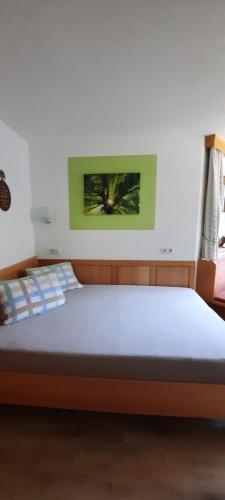 ein Bett in einem Schlafzimmer mit einem Bild an der Wand in der Unterkunft Appartement Margreiter in Niederau