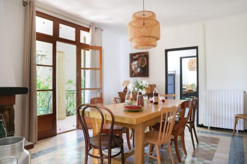 uma sala de jantar com uma mesa de madeira e cadeiras em La Bohème à Lacoste em Lacoste