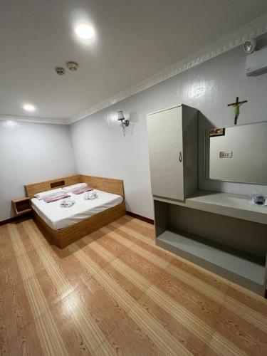 Habitación con cama y lavabo. en Ging-Ging Tourist Inn, en Badian