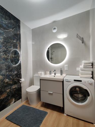 a bathroom with a washing machine and a sink at Panda in Wrocław