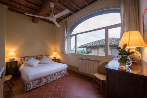 a bedroom with a bed and a large window at Fattoria di Mandri in Reggello