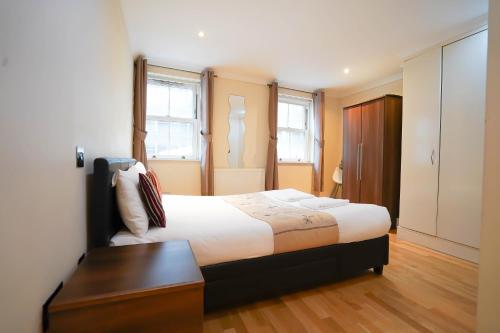 a bedroom with a large bed and a wooden floor at Cosy 2-Bed 2 Bathroom Apartment in London in London