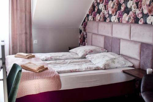 a bedroom with a large bed with a floral wall at Jarzębinowy Resort & SPA in Braniewo