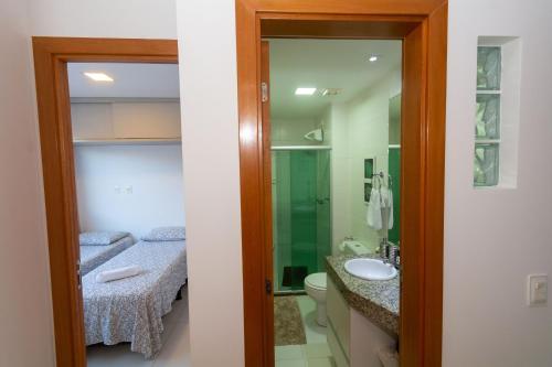 a bathroom with a sink and a toilet and a mirror at Condominio Solaris Imbassaí in Imbassai