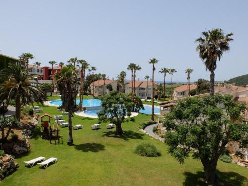 an aerial view of a resort with a pool and palm trees at HG Jardín de Menorca in Son Bou