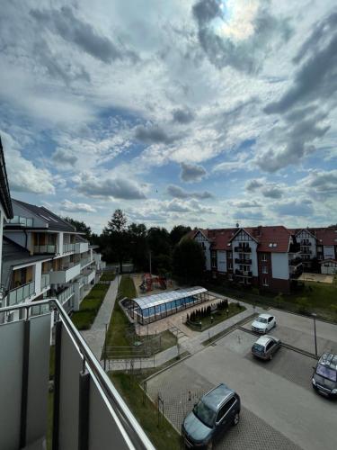 een uitzicht op een parkeerplaats met auto's op straat bij Baltic Garden apartament dwupoziomowy 56 m² in Sztutowo