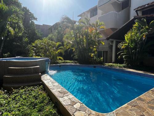 une grande piscine bleue en face d'une maison dans l'établissement Todo lo que necesitas en un solo lugar..., à Pampatar