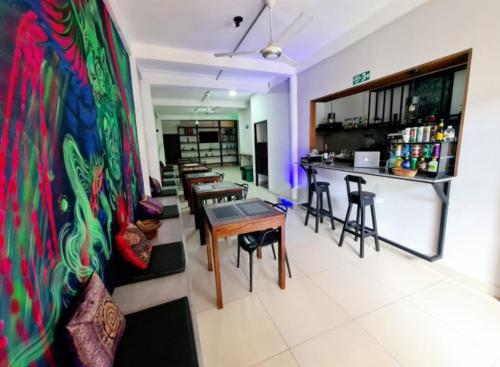 een kamer met tafels en stoelen en een bar bij 3F Apartments in Leticia