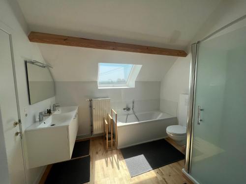 a bathroom with a tub and a sink and a toilet at Le Gîte du Jardinier in Tournai