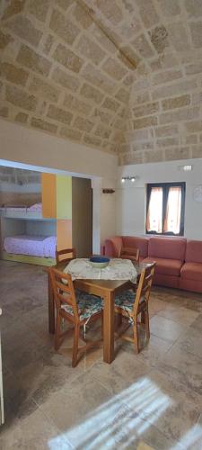 een kamer met een tafel en stoelen en een bank bij Casa Alisea in Castellaneta