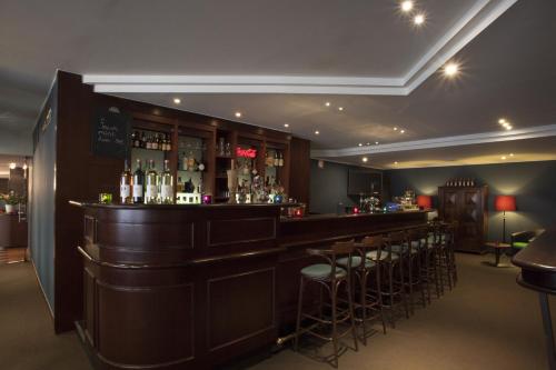 a bar with a row of stools in a room at Theater Hotel in Antwerp