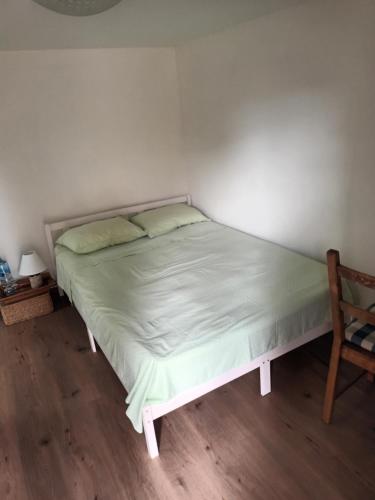 een bed in een kleine kamer met een stoel bij Camera con bagno in Ploieşti