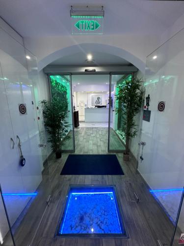 een badkamer met een douche en een blauw zwembad bij Thalia deco City & Beach Hotel in Chersonissos