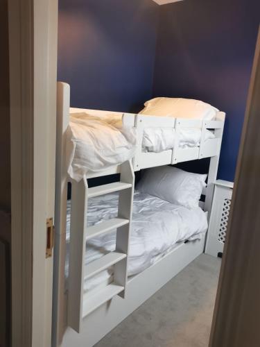 a bunk bed with white bunk beds in a room at Mount Juliet luxury residence in Ballylinch Bridge