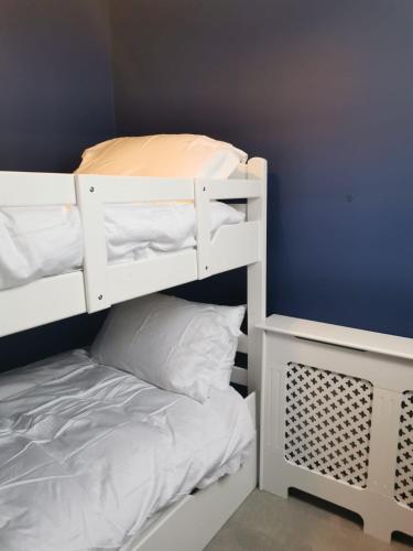 a white bunk bed in a room with a blue wall at Mount Juliet luxury residence in Ballylinch Bridge