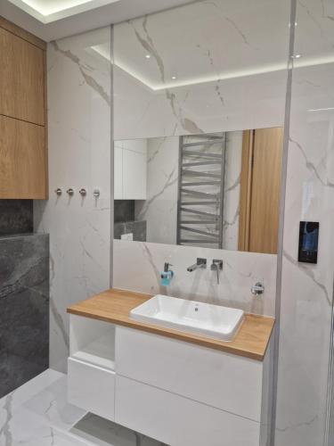 a white bathroom with a sink and a mirror at Apartament Platinum z tarasem 70 m2, 50 m od Placu Litewskiego in Lublin