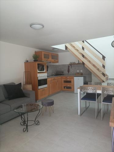 cocina y sala de estar con sofá y mesa en Gite paisible, en Seyssel