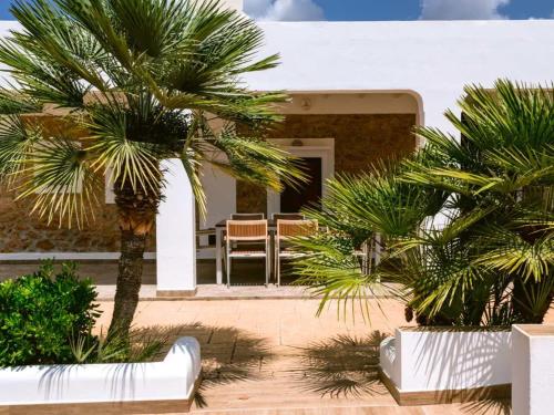 a house with two palm trees in front of it at Can Pep Luis Pep Mortera near to Playa Den Bossa in Ibiza Town