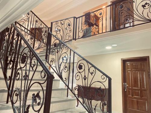a staircase with wrought iron railings in a house at Joyous AP Guest House in Aburi