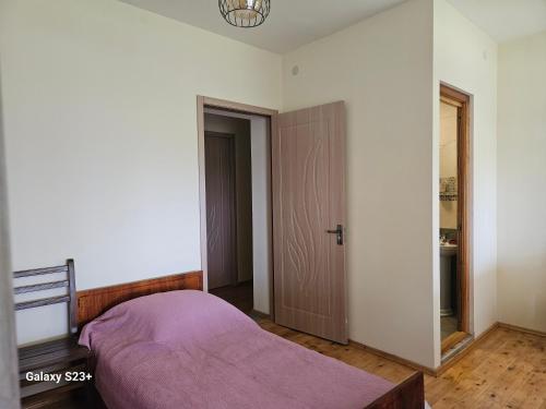 a bedroom with a bed with a purple blanket at Guest house T/S in Lagodekhi / khizabavra in Khizabavra