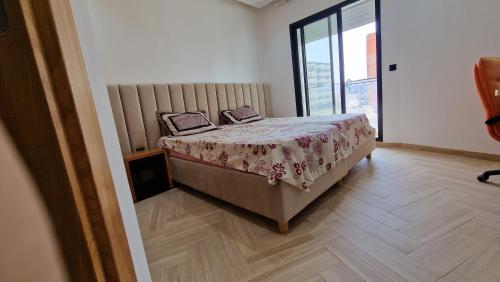sypialnia z łóżkiem i dużym oknem w obiekcie Lovely apartment in Monastir w mieście Monastir