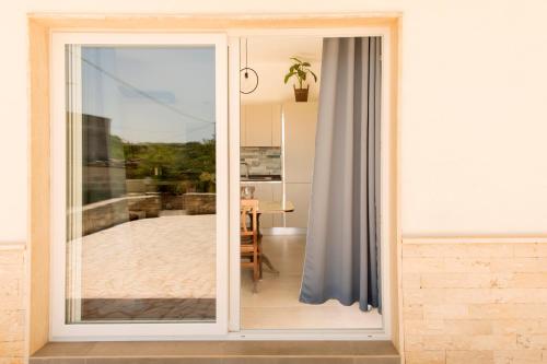 a sliding glass door with a view of a patio at Villa Comes in Monopoli