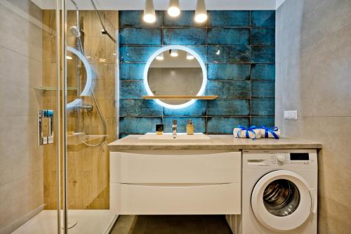 a bathroom with a sink and a washing machine at BlueApart Apartamenty Na Klifie in Władysławowo