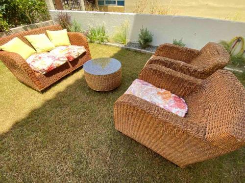 two wicker chairs and a table in a yard at Magio House in Ixia