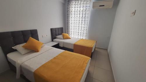 a small room with two beds and a window at kerim apart tatil evleri in Fethiye