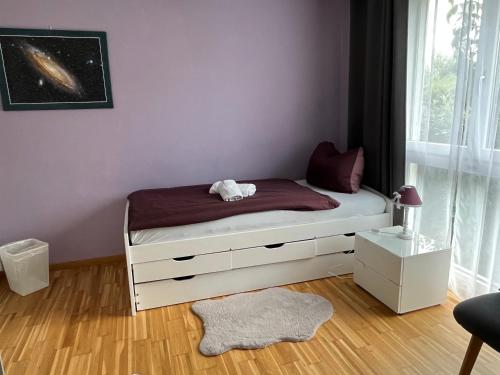 1 dormitorio con 1 cama con pared morada en Oasi 2 en Kreuzlingen
