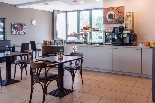 ein Restaurant mit Tischen und Stühlen und eine Küche in der Unterkunft Hobbit Hotel Mechelen in Mechelen