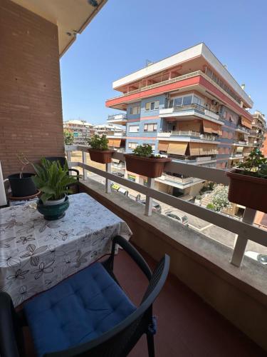 a table and chairs on a balcony with a building at Al Porto Di Roma B&B in Lido di Ostia