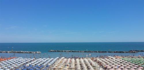 un gruppo di ombrelloni su una spiaggia con l'oceano di Hotel Villa Mon Reve a Rimini