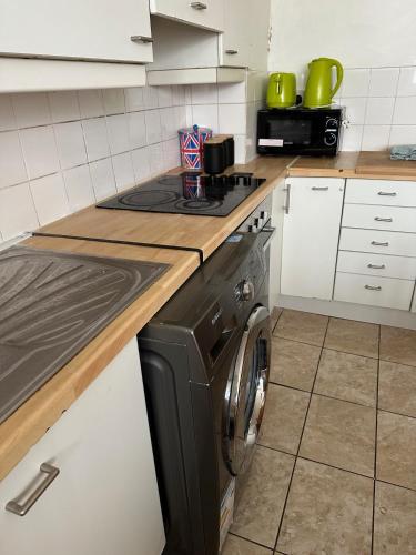 a kitchen with a stove and a washing machine at Whites Inn in London