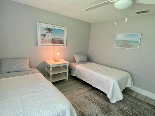 Zimmer mit 2 Betten und einem Tisch mit einer Lampe in der Unterkunft House on Hibiscus: #SiestaBeach in Sarasota