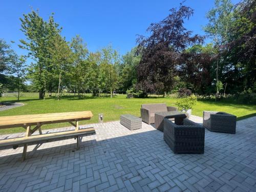 a patio with a picnic table and chairs in a park at Le Gîte du Jardinier in Tournai
