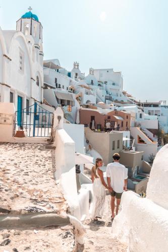 a bride and groom walking down the stairs of a house at Aspaki by Art Maisons in Oia