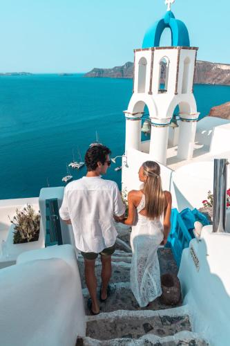 a man and a woman standing on the steps of a building at Aspaki by Art Maisons in Oia