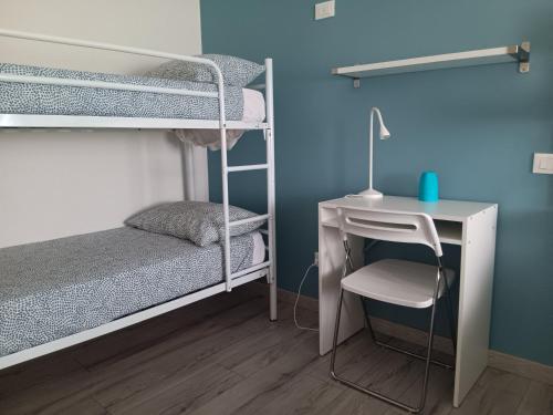 a bedroom with bunk beds and a desk and a bed at ACCADEMIA Rooms in Livorno