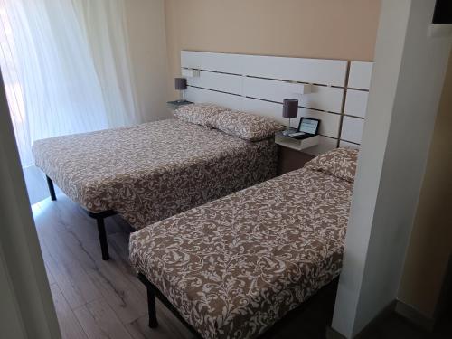 a bedroom with two beds and a headboard at ACCADEMIA Rooms in Livorno