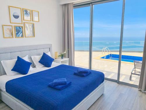 um quarto com uma cama azul e vista para o oceano em Villa Céu e Mar em Prazeres