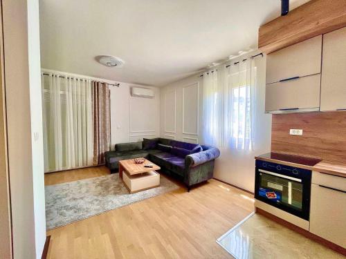 uma sala de estar com um sofá e uma mesa em BS Apartman em Podgorica