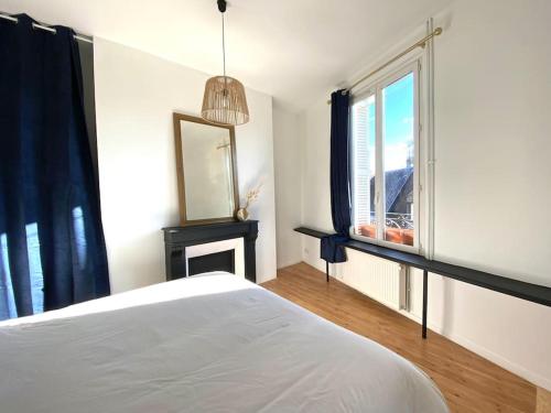 um quarto com uma cama branca e uma janela em The Jungle Flat em Rouen